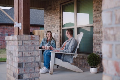 Smiling couple enjoying coffee from their front porch