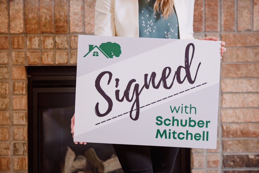 Signed with Schuber Mitchell sign in front of fireplace