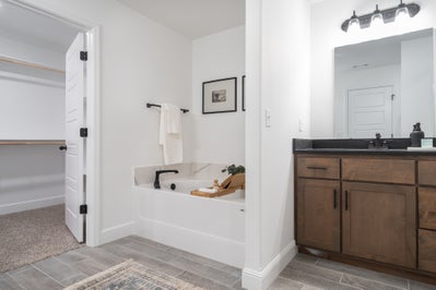 Primary bathroom offering tub and custom cabinets