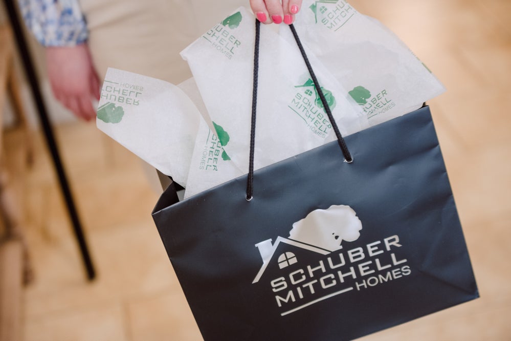 Gift bag with the Schuber Mitchell Homes logo on the side
