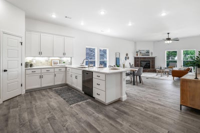 Kitchen with white cabinets, white counters and a view of the expansive living space