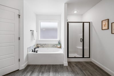 Separate shower and tub shown with photos framed on the wall