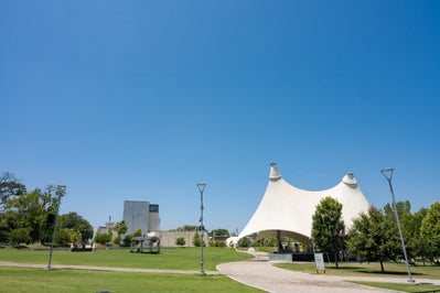 Large lawn area with large white tent in front of local art museum